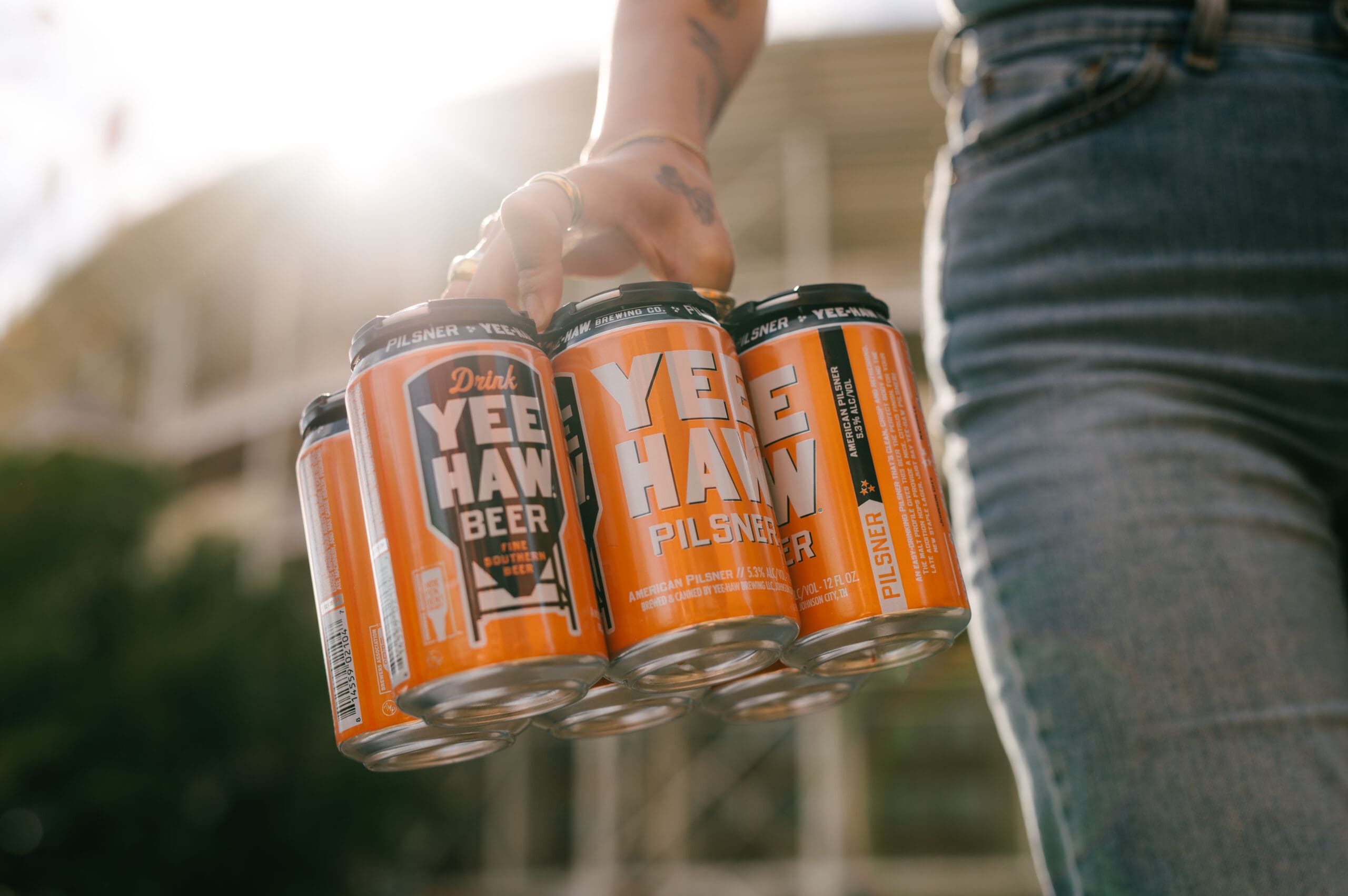 Women holding six pack of Yee-Haw Pilsner