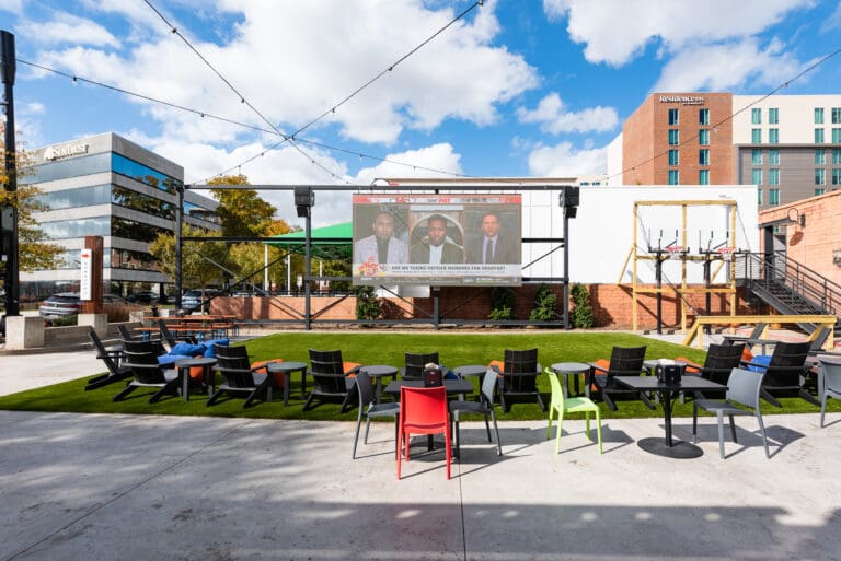 Empty beer garden with big screen and chair on grass at Yee-Haw Greenville, SC